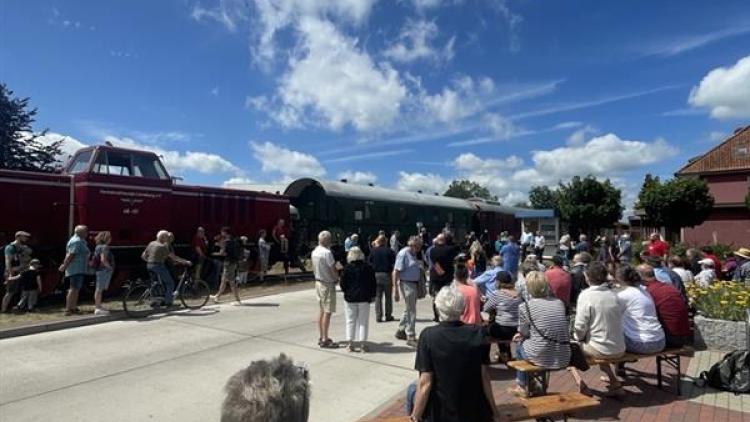 Zug der Bleckeder Kleinbahn an der Haltestelle Erbstorf Ziegelei, Menschen winken, FDP-Fahne, Sonnenschein, Familienatmosphäre